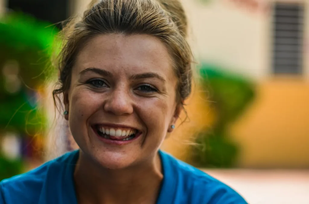 A friendly woman in a blue top smiles warmly